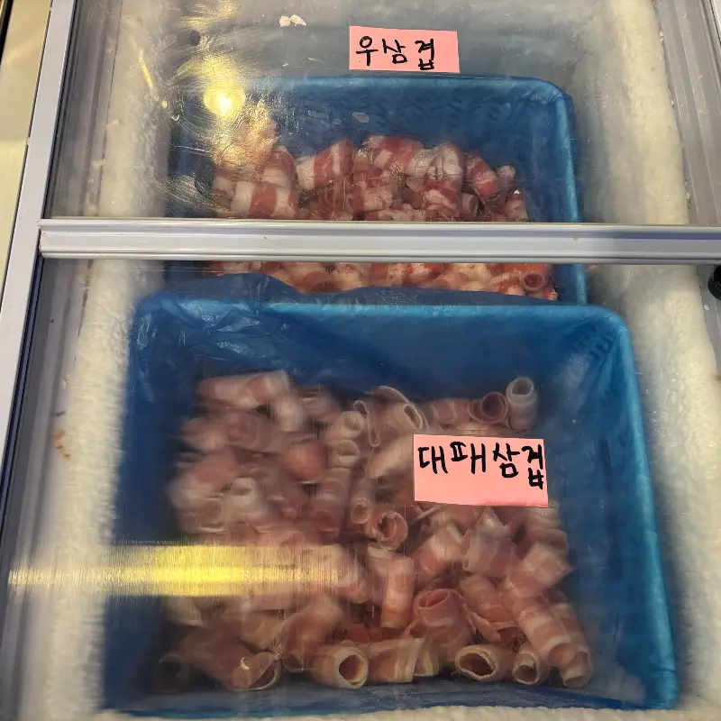 냉동 쇼케이스 안에 가지런히 놓인 우삼겹과 대패삼겹살
