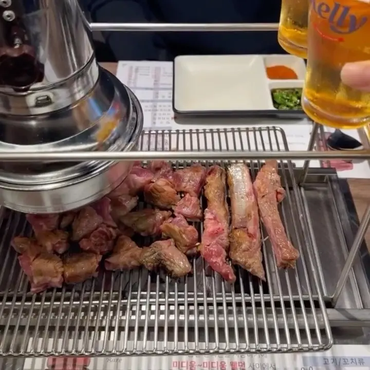 숯불 위에서 구워지는 양꼬치와 맥주