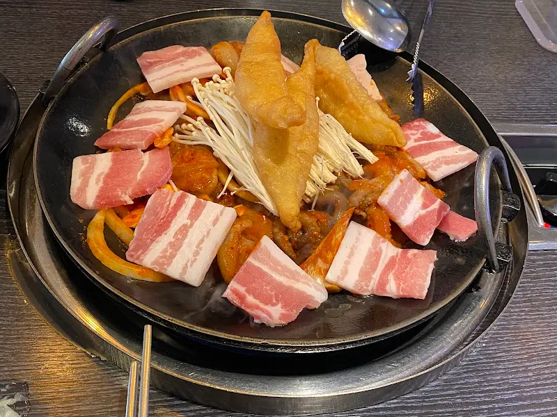 불판 위에서 쭈꾸미와 삼겹살이 맛있게 익어가는 모습