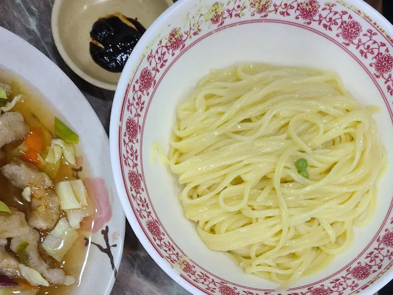 유니짜장 소스와 면이 따로 담겨 나온 모습. 짜장 소스는 윤기가 흐르며, 면은 탱글탱글한 느낌을 준다.