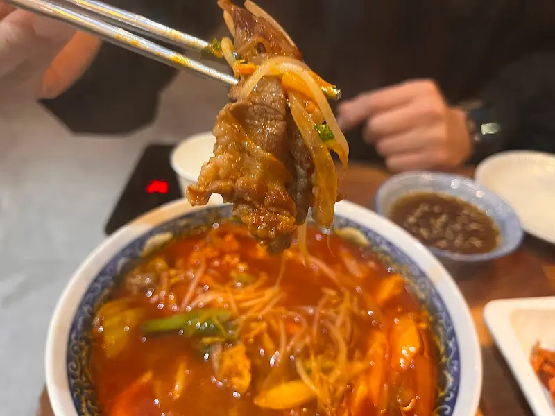 우삼겹을 짬뽕 국물에 적셔 먹는 모습