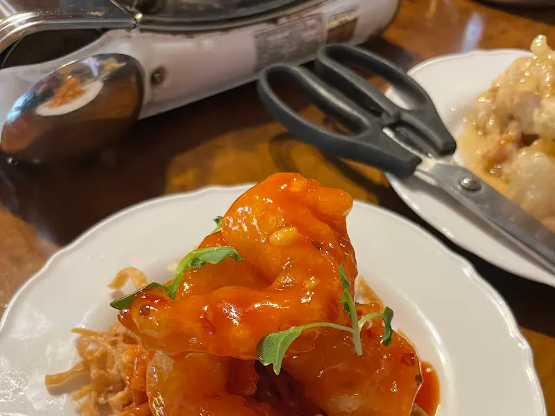 테이블 위에서 보글보글 끓고 있는 마라 곱창 전골과 칠리 새우