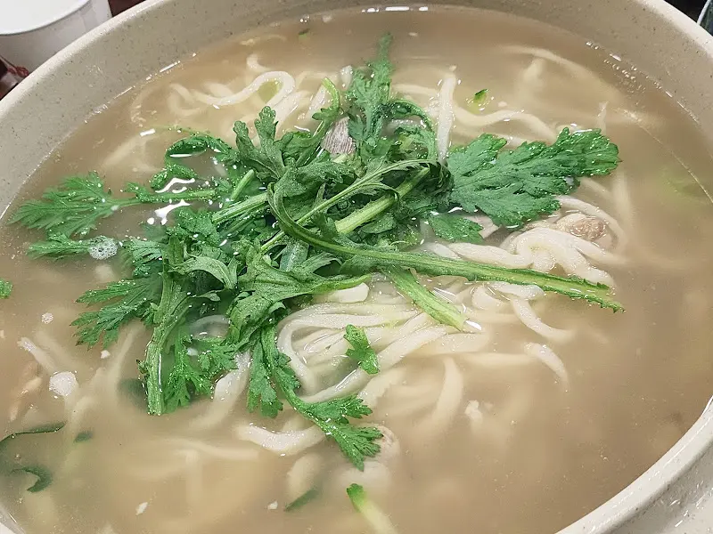 쑥갓이 듬뿍 올려진 손칼국수의 모습