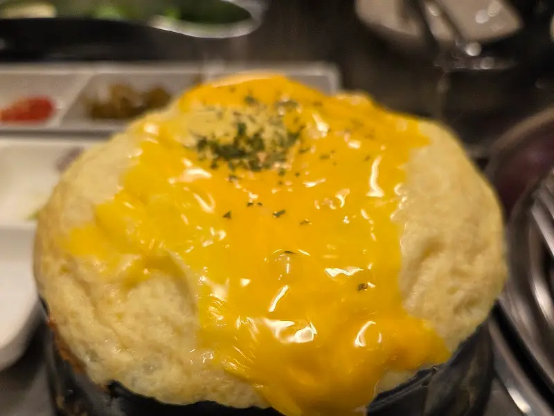 잘 익은 고기를 젓가락으로 집어 올리는 모습