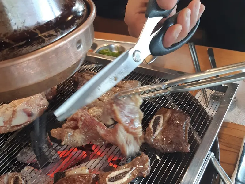 집게와 가위를 이용해 고기를 자르는 모습