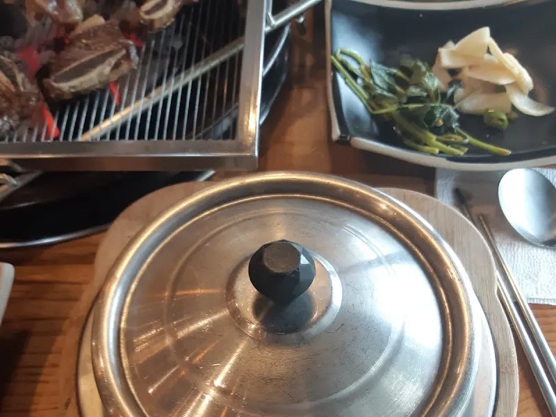 숯불, 솥밥, 밑반찬이 차려진 테이블