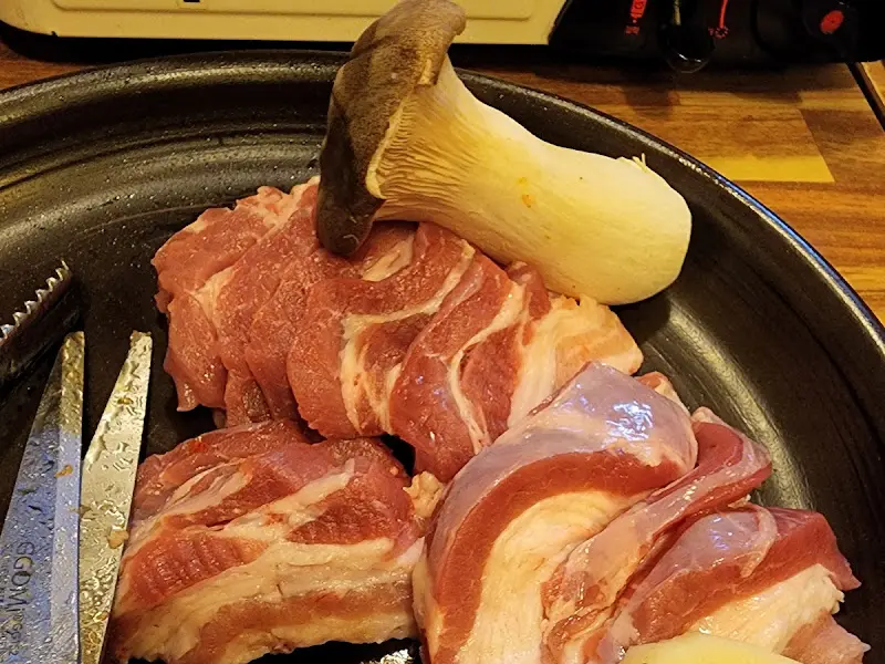 두툼한 삼겹살과 버섯이 함께 구워지는 모습
