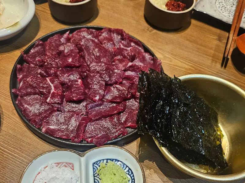 뭉티기와 김, 소스 등이 테이블 위에 놓인 모습