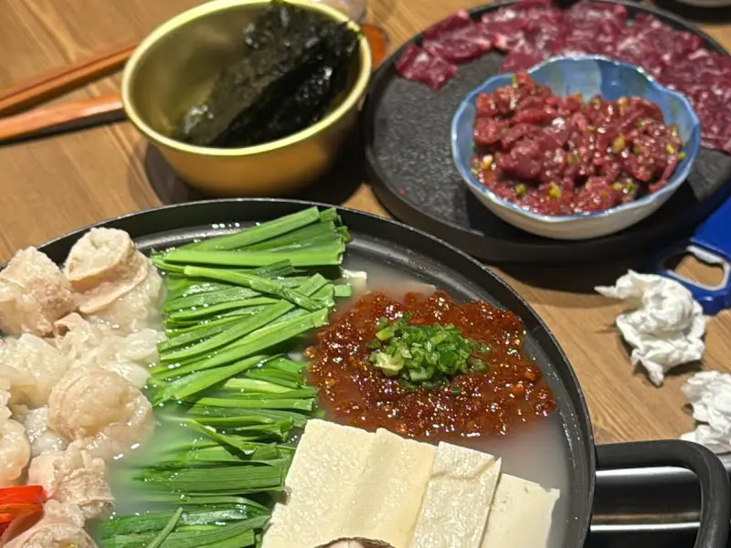 뭉티기, 육회, 탕 등의 메뉴가 함께 놓인 테이블의 모습