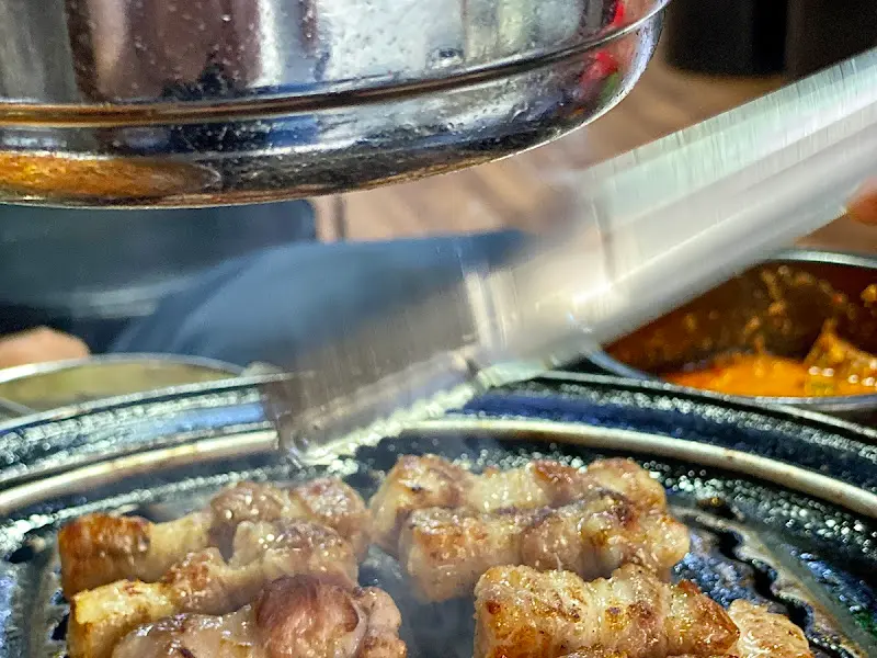 능숙한 손놀림으로 고기를 자르는 직원