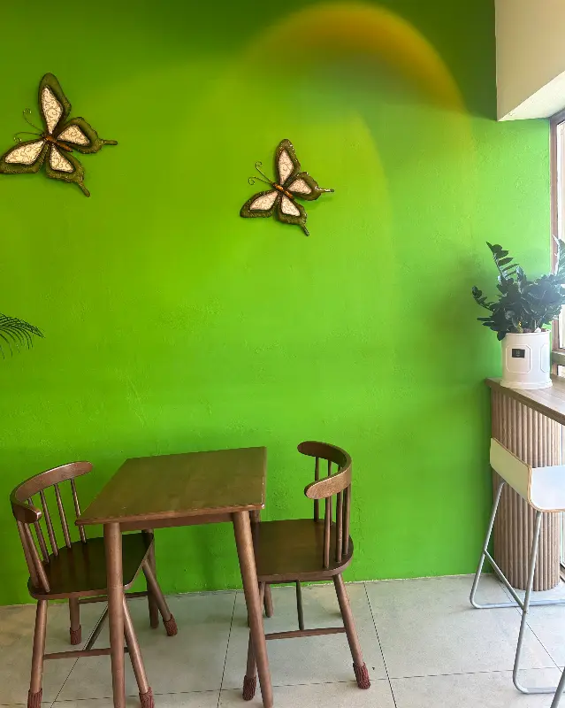 카페 내부 테이블과 초록색 벽