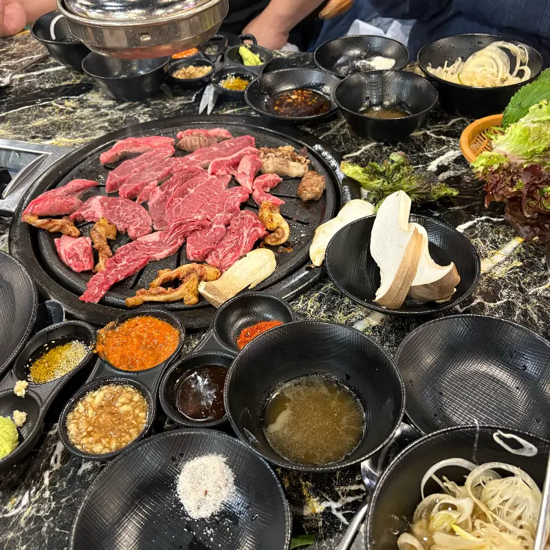 숯불 위에서 익어가는 소고기와 돼지고기