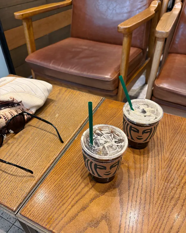 나무 테이블 위에 놓인 아이스 음료 두 잔