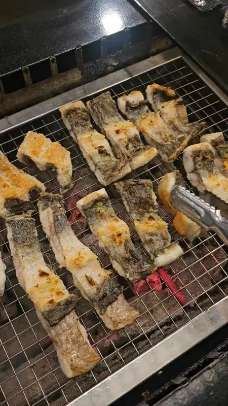 장어 한 점을 집어 올리는 모습