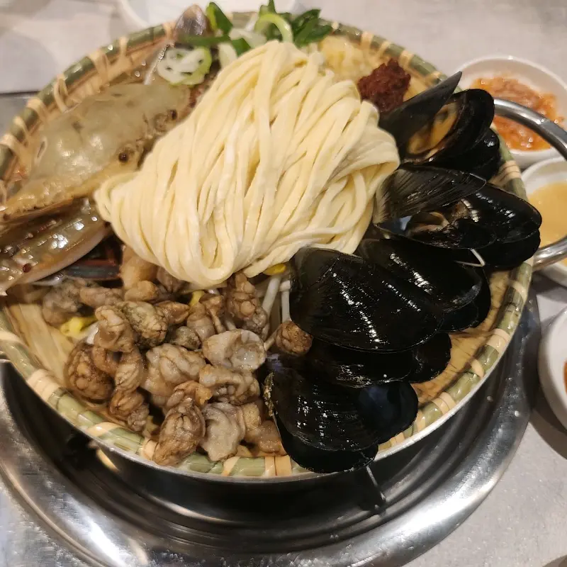 꽃게, 홍합 등 해산물과 면이 담긴 칼국수 재료