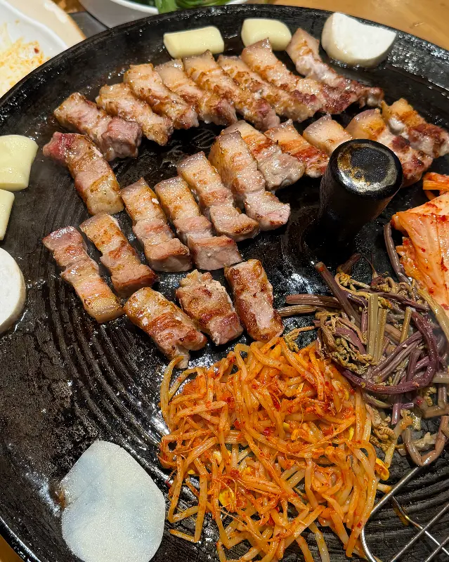 불판 위 삼겹살, 김치, 콩나물, 고사리