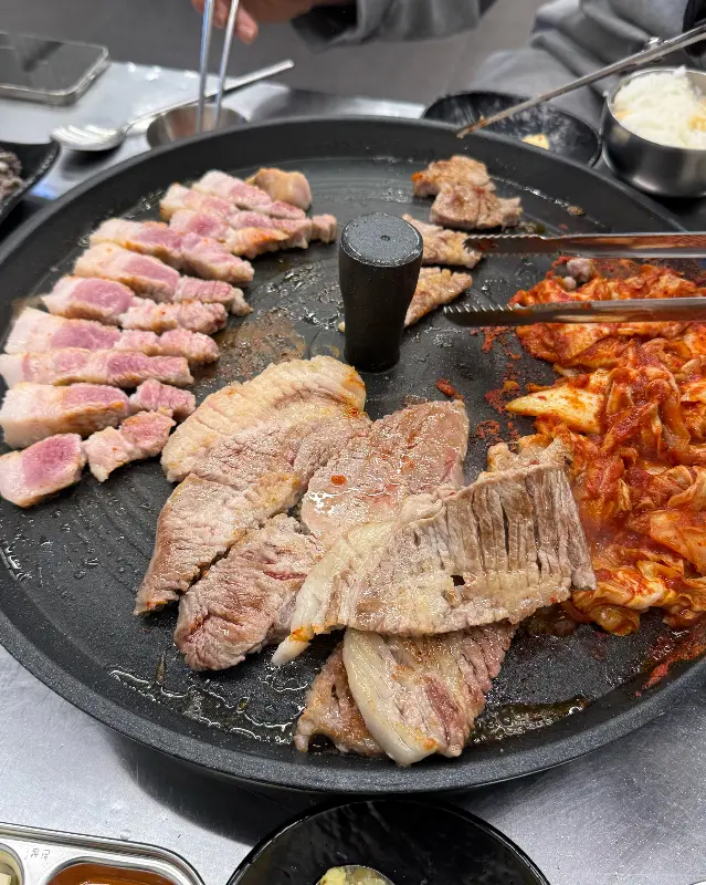 잘 익은 삼겹살을 쌈에 싸서 먹는 모습