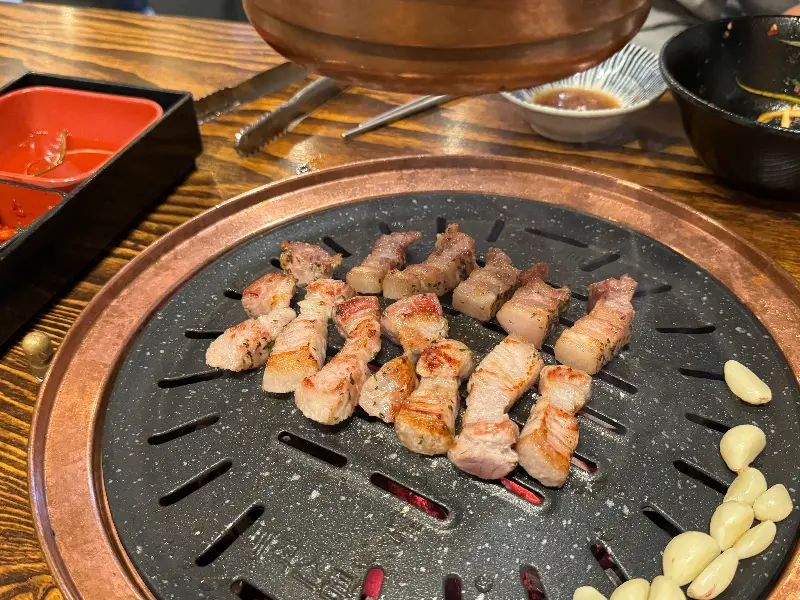 불판 위에서 익어가는 삼겹살과 마늘