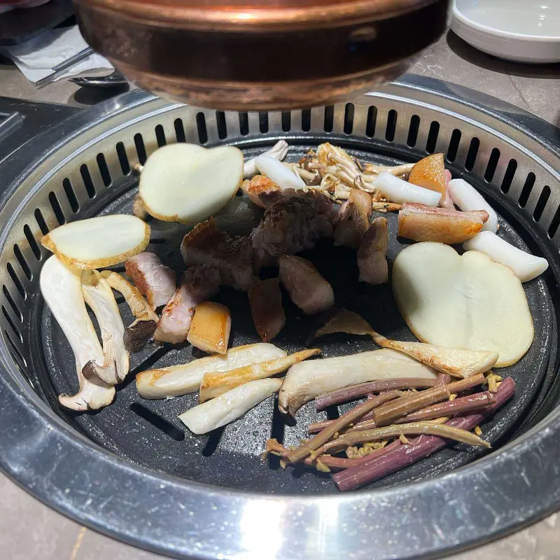 불판에 구워진 고기와 채소