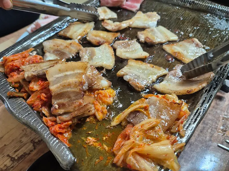 냉동 삼겹살과 김치를 함께 구워먹는 모습