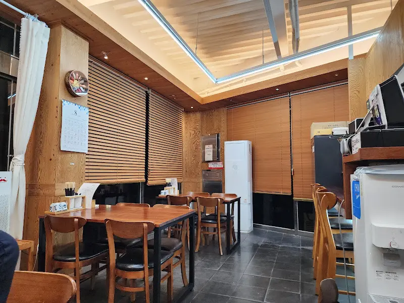 테이블과 의자가 정갈하게 놓여 있는 윤초밥 내부