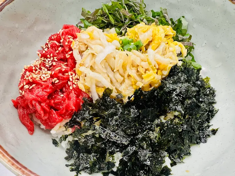 선홍빛 육회와 묵은지의 조화가 아름다운 육회비빔밥