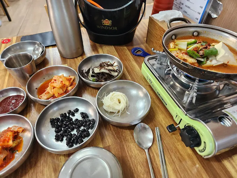 다양한 밑반찬과 물회 육수가 담긴 냄비