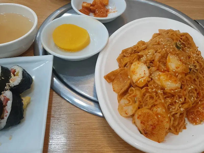 테이블 위에 놓인 라볶이, 김밥, 단무지, 김치, 오뎅국 사진
