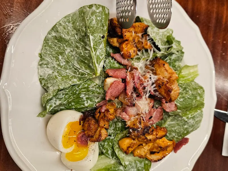 접시에 담긴 샐러드 클로즈업 사진. 신선한 야채와 구운 닭고기, 삶은 계란이 조화롭게 담겨 있다.