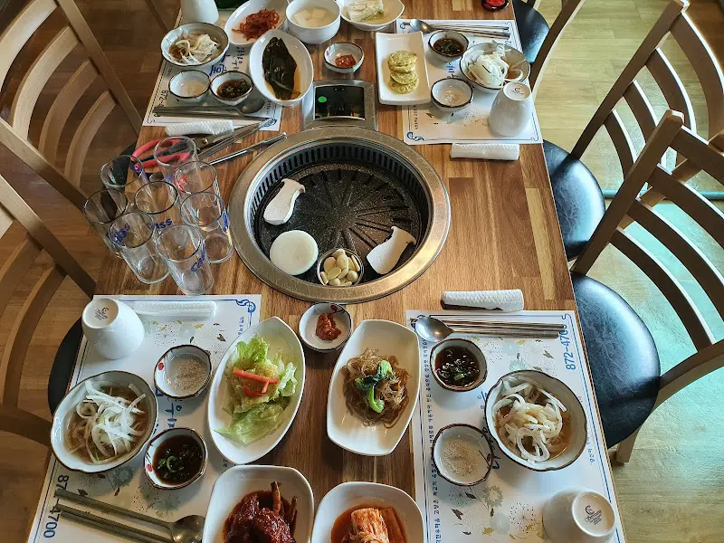 테이블 가득 차려진 밑반찬과 한우