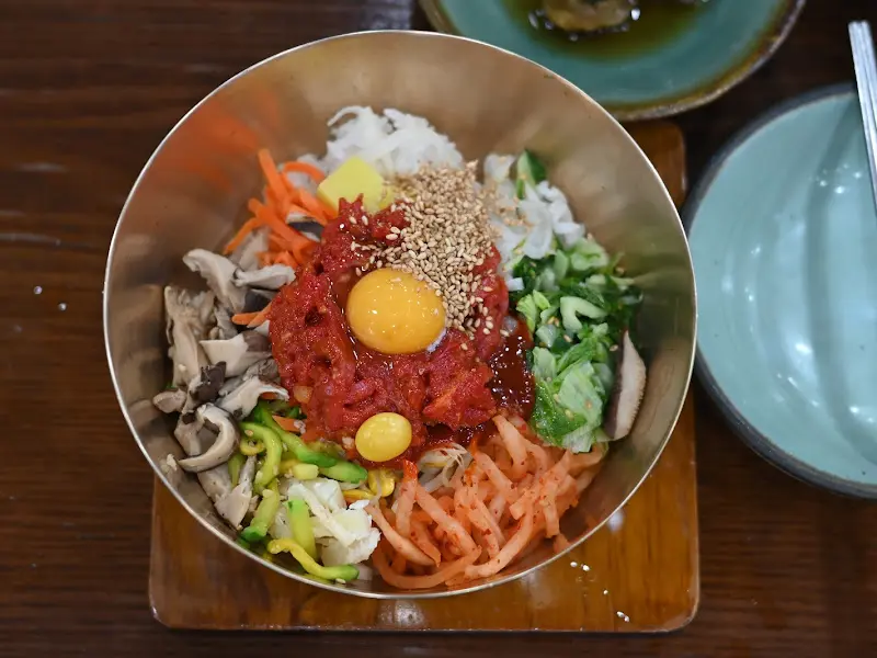 놋그릇에 담긴 육회비빔밥의 모습