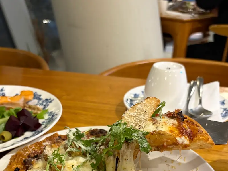 페스츄리 피자 한 조각을 들어올린 모습