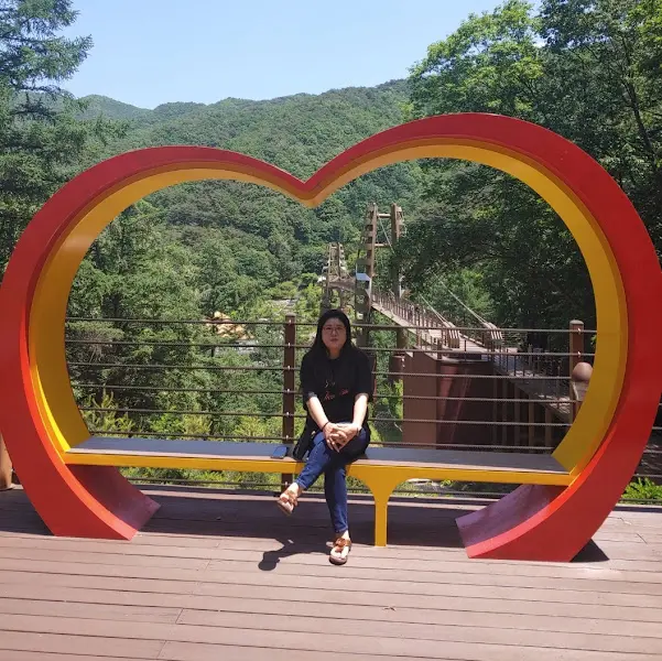 하트 조형물 앞의 여성