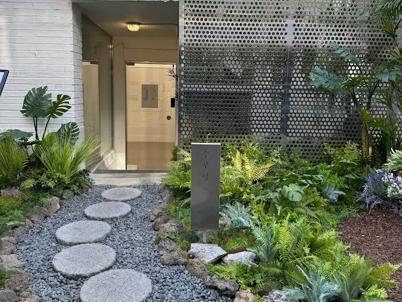 싱그러운 식물과 돌길로 꾸며진 샤브라운지 입구