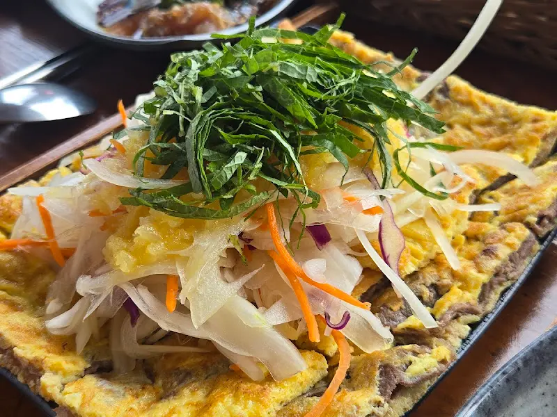 육전 위에 양파채와 샐러드가 곁들여진 모습