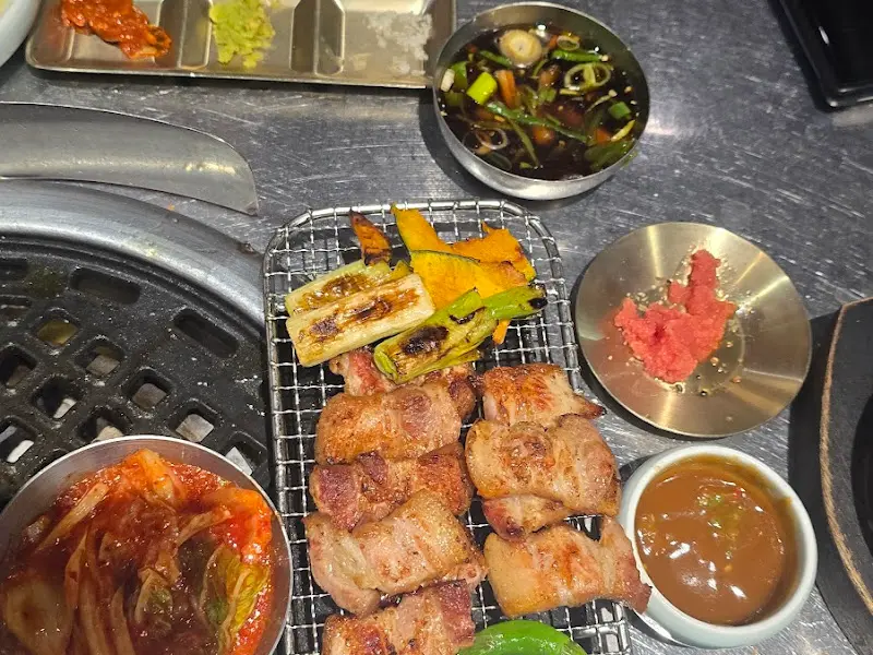 불판 위에 올려진 잘 익은 고기와 꽈리고추, 호박