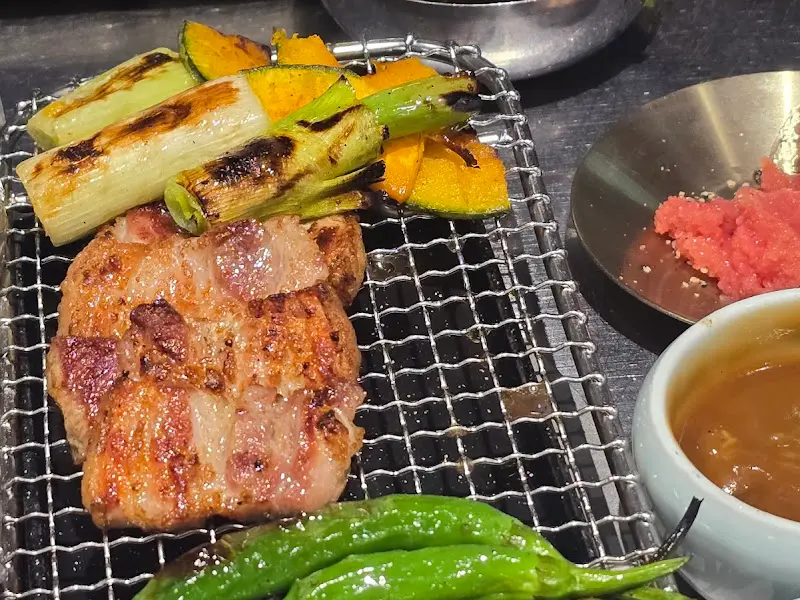 잘 구워진 고기와 함께 꽈리고추, 호박이 불판 위에 놓여있는 모습