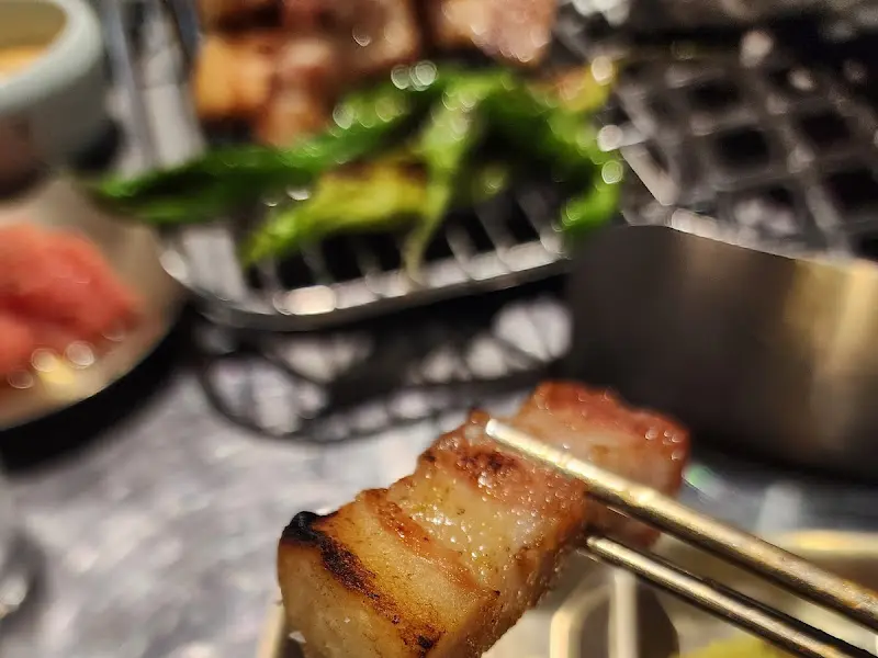 젓가락으로 집어 올린 숙성 삼겹살