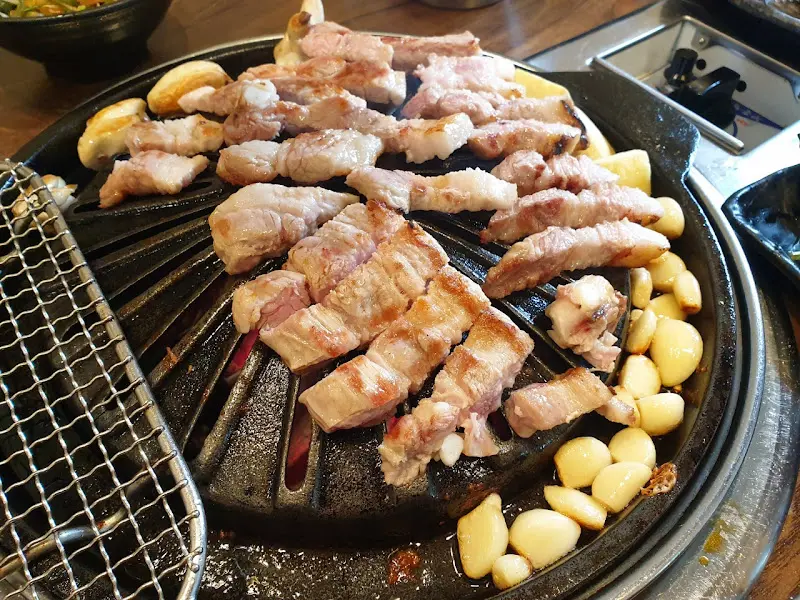 삼겹살과 마늘이 함께 구워지는 모습