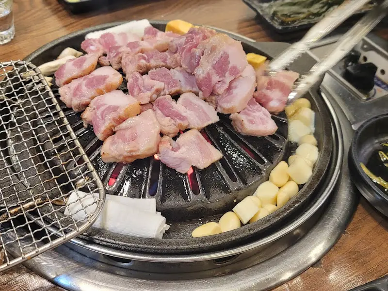 불판 위에 삼겹살이 가득 올려진 모습