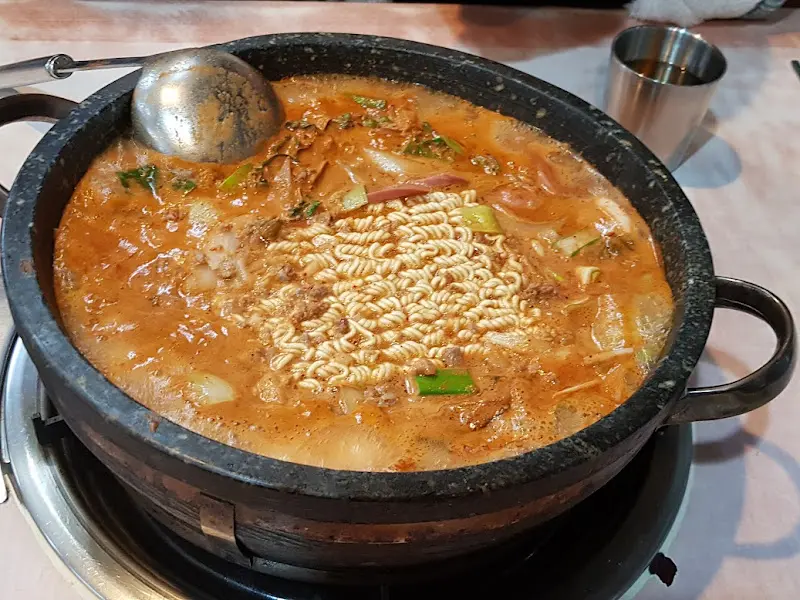 국자로 부대찌개를 뜨는 모습