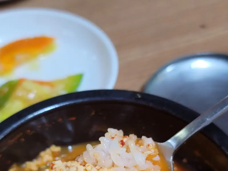 숟가락 위에 올려진 두부와 밥알