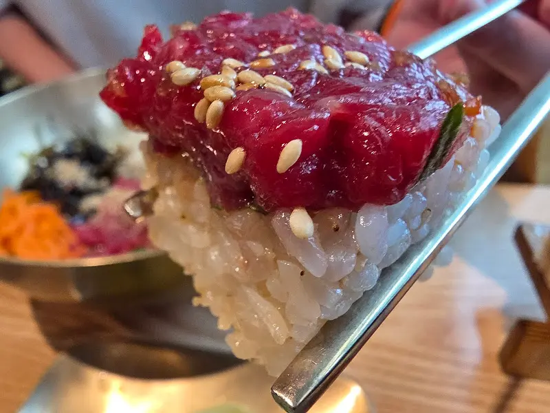 젓가락으로 집어 올린 육회초밥