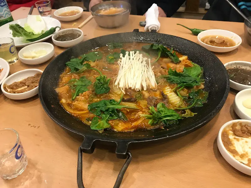 푸짐한 쑥갓과 팽이버섯이 올려진 곱창전골