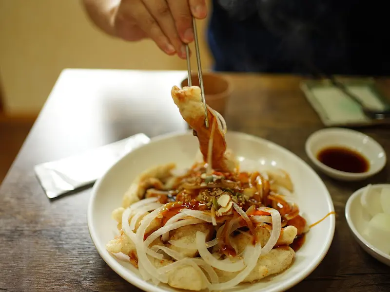 젓가락으로 탕수육을 집어 올리는 모습