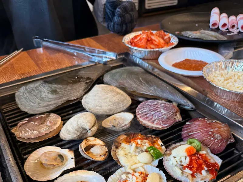 불판 위에서 익어가는 다양한 조개들