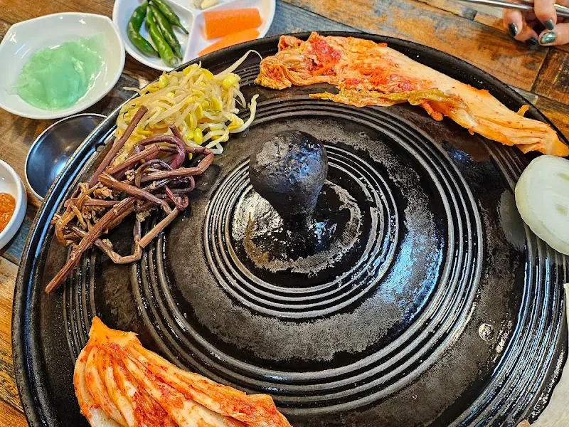 솥뚜껑에 구워진 김치와 삼겹살