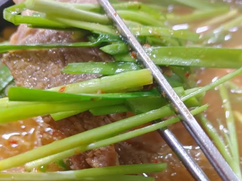 젓가락으로 집어 올린 흑염소 고기