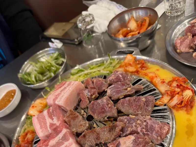 불판 가장자리에 둘러진 달걀 크러스트와 김치