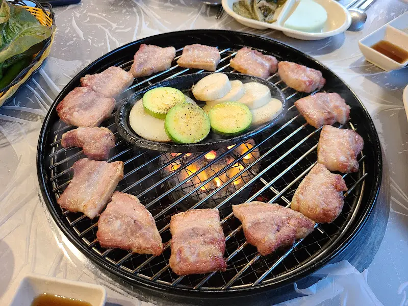 불판 위에서 노릇하게 익어가는 꽃삼겹살